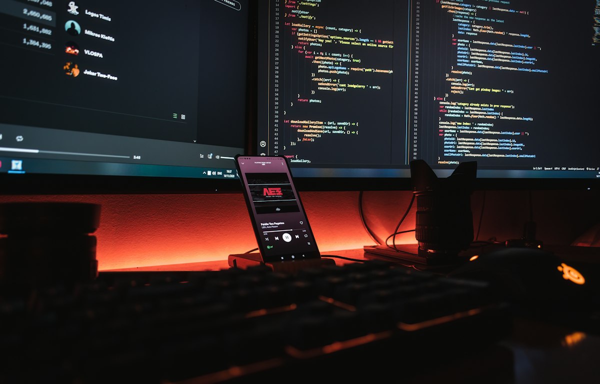 Lines of code on a laptop screen in a dark room — a generic stock photo representing software vulnerability research and cybersecurity, not the actual disclosure materials