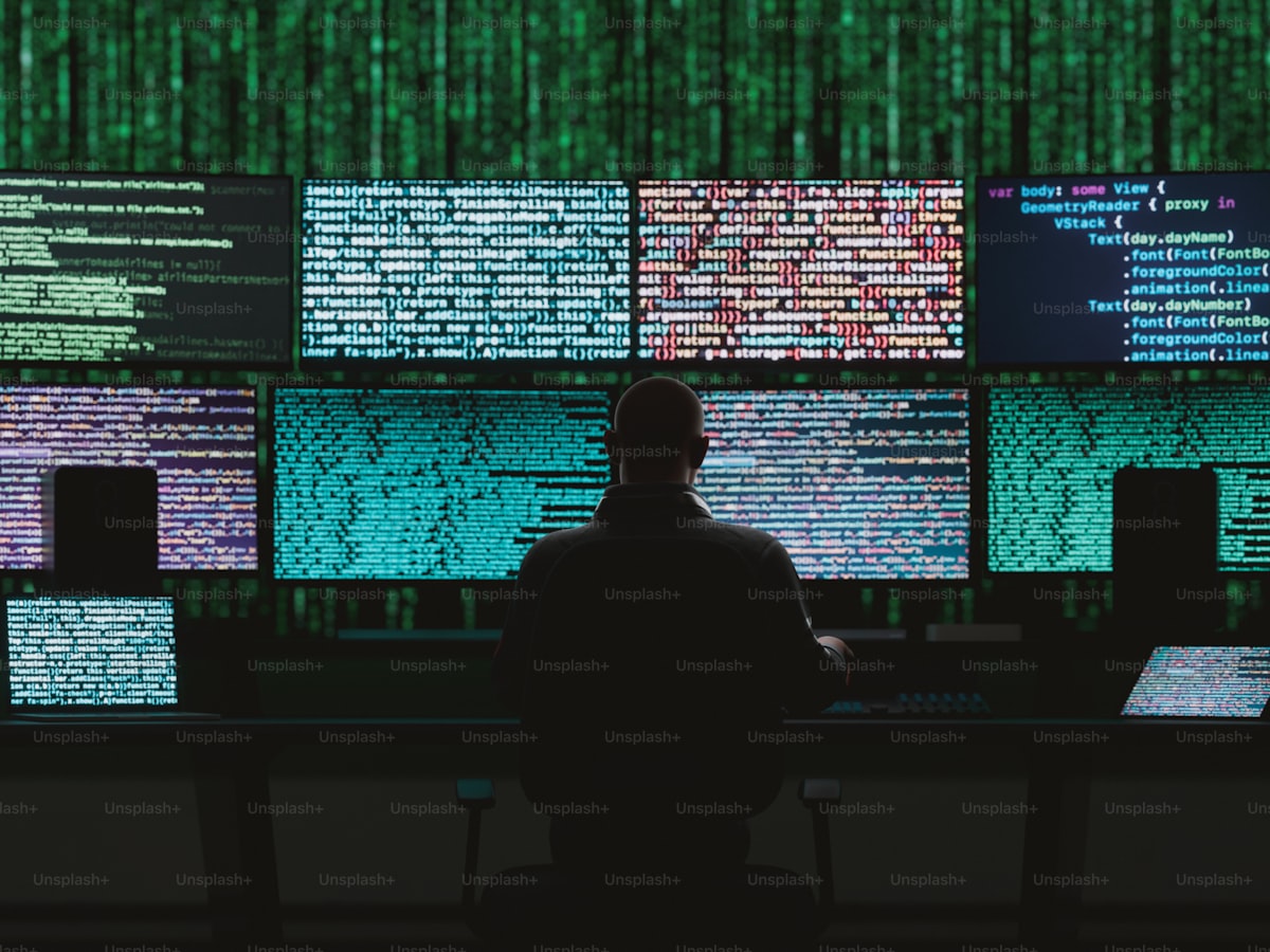 A silhouetted figure standing before walls of glowing green code — a generic hacker stock photo, not an actual statistics graphic