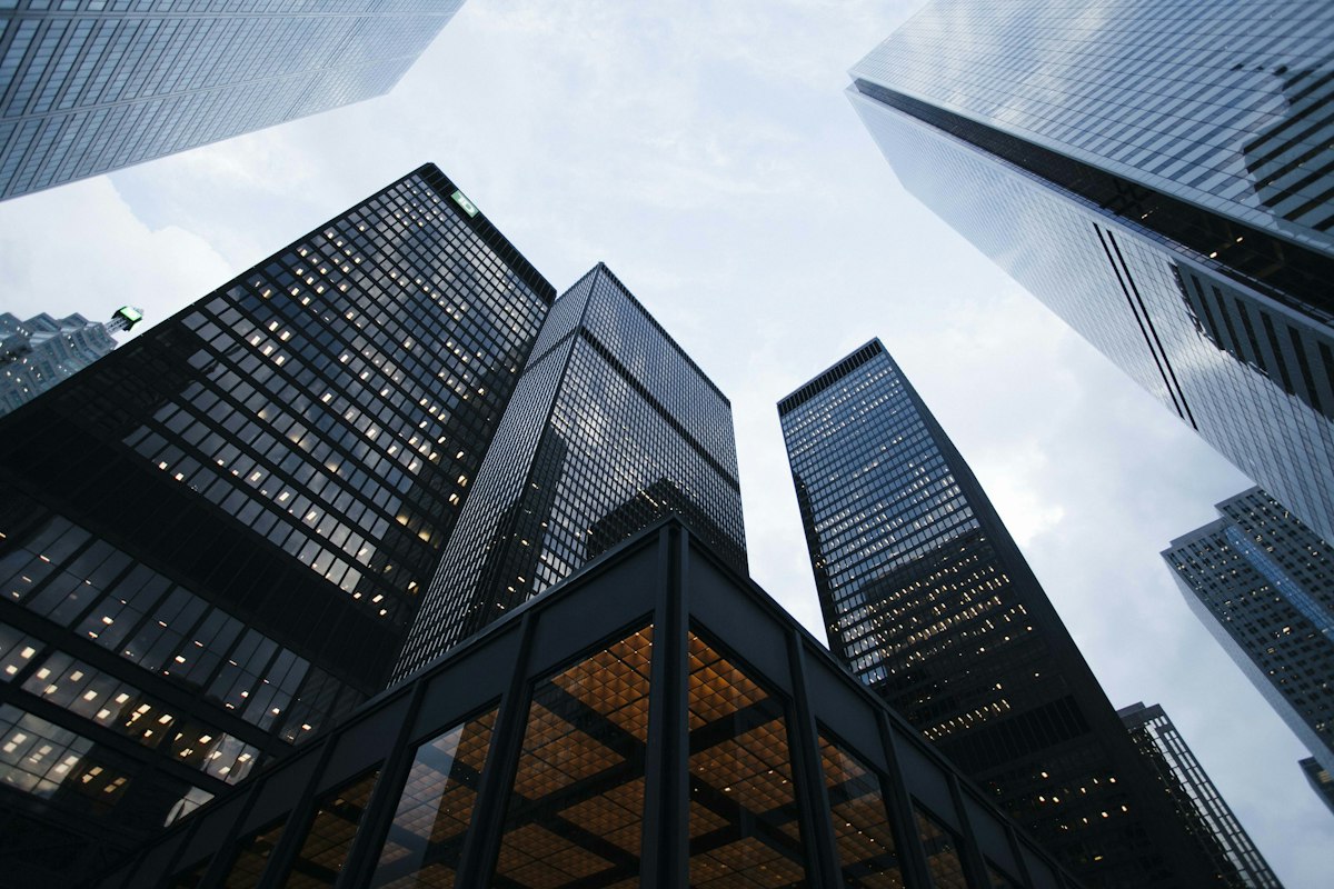 Glass office towers photographed from street level looking up — generic stock photo representing corporate institutions and the state-level litigation patchwork, not an actual courthouse involved in these lawsuits